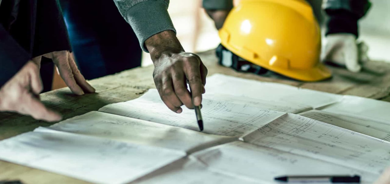 Construction workers looking at reports. 