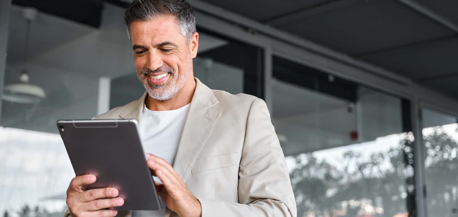 Man smiling and holding a tablet. 